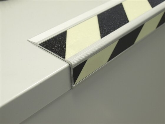 PELDAÑO FOTOLUMINISCENTE CEBRADO CLASE A APLICADO CON TORNILLOS A LA ESQUINA DIMENSION 7 CM X 3,5 CM X 1 M